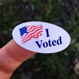 An "I Voted" sticker on a person's finger